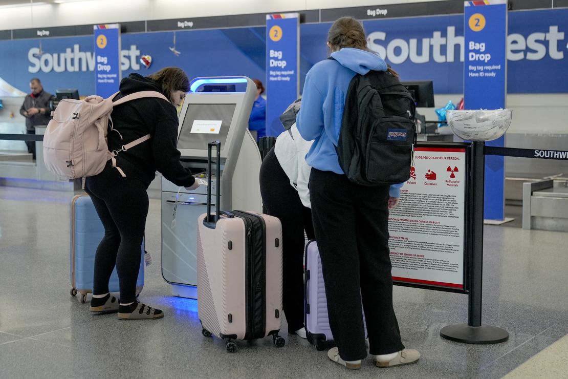 Travelers use Southwest Airlines kioks to check bags at Midway International Airport, Tuesday, March 11, 2025, in Chicago. (AP Photo/Erin Hooley)