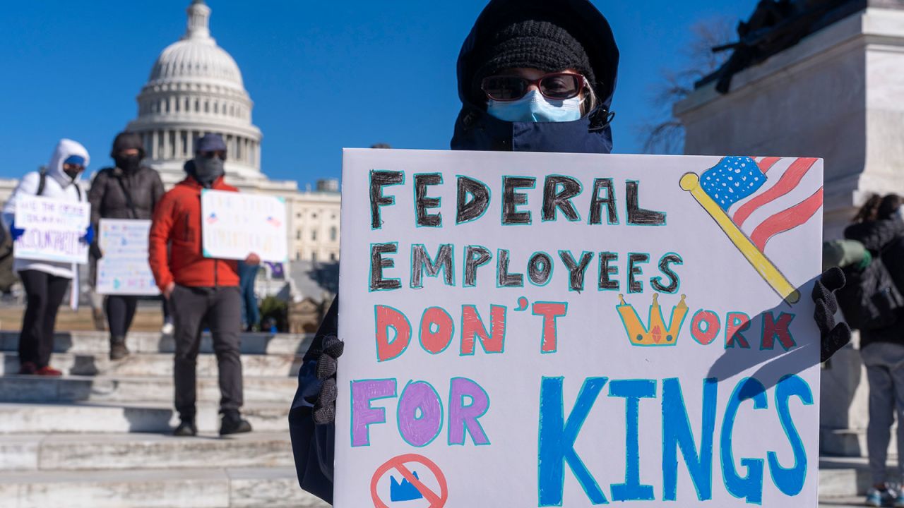 FILE - A federal employee, who asked not to use their name for fears over losing their job, protests with a sign saying "Federal Employees Don't Work for Kings" during the "No Kings Day" protest on Presidents Day in Washington, in support of federal workers and against recent actions by President Donald Trump and Elon Musk, Feb. 17, 2025, by the Capitol in Washington. (AP Photo/Jacquelyn Martin, File)
