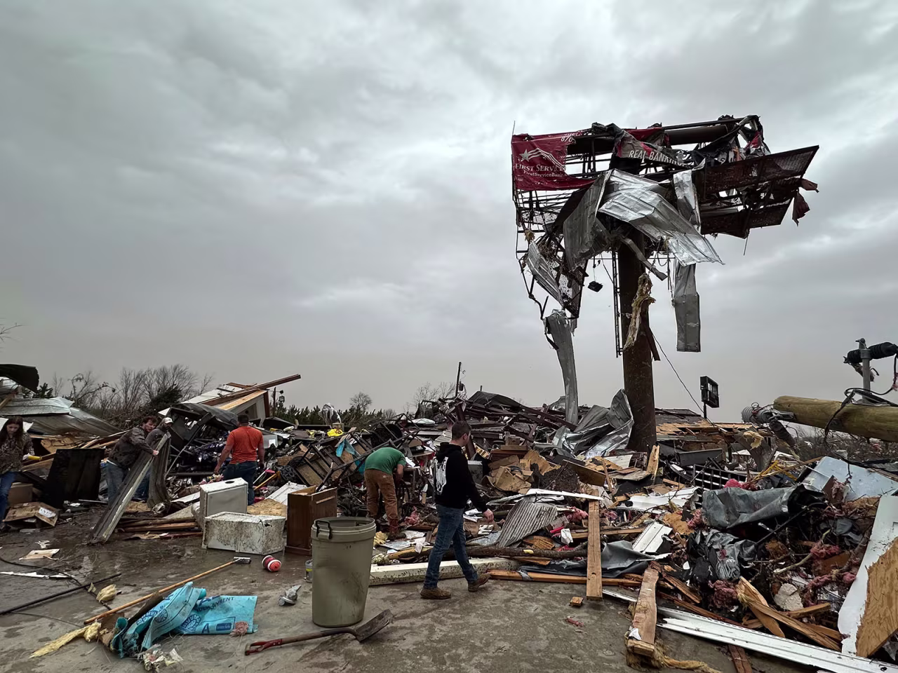 People work through the debris of the Cave City Auto Parts store on Saturday, in Cave City, Arkansas.