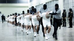 En esta fotografía proporcionada por la oficina de prensa de la presidencia de El Salvador, guardias penitenciarios trasladan a deportados de Estados Unidos al Centro de Confinamiento por Terrorismo en Tecoluca, El Salvador, el domingo 16 de marzo de 2025.