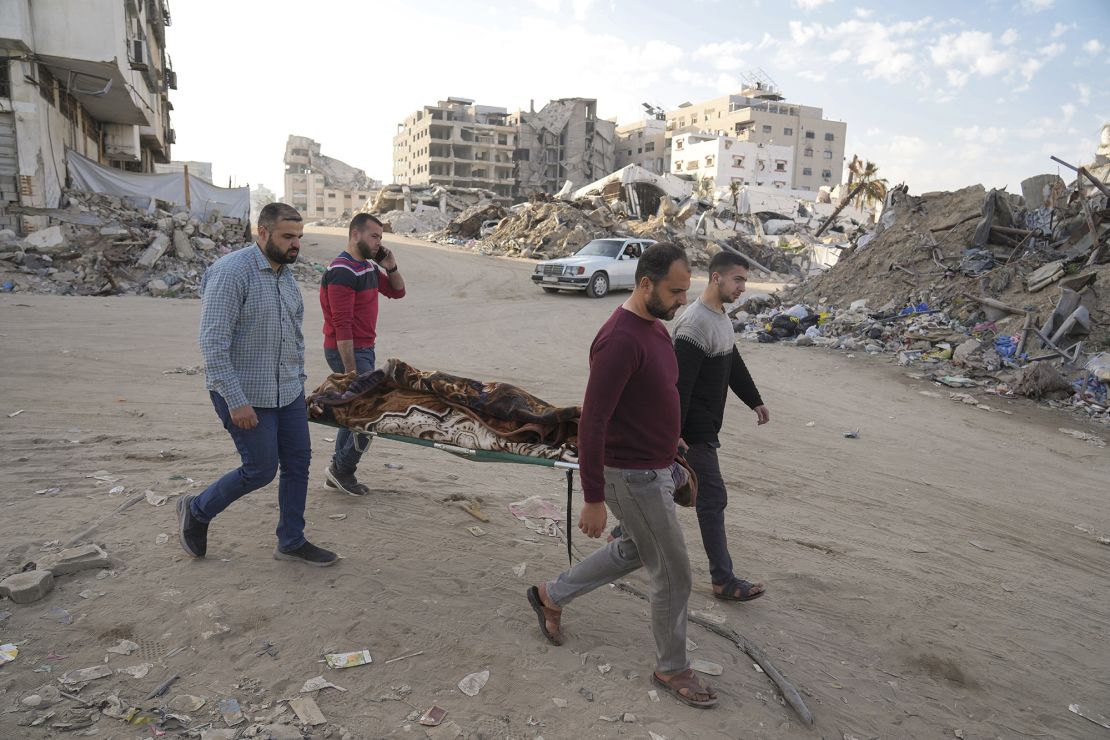 Men carry the body of Palestinian man killed in an Israeli airstrike in Gaza City on Tuesday.