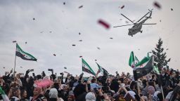 Confetti and flowers are dropped from a military helicopter onto a crowd during a celebration marking the 10th anniversary of the victory of rebel forces over Bashar al-Assad's army in Idlib, Syria, Friday, March 28, 2025.