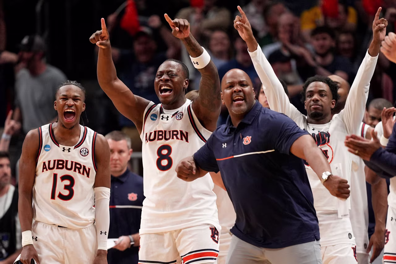 The Auburn bench celebrates during the against Michigan.