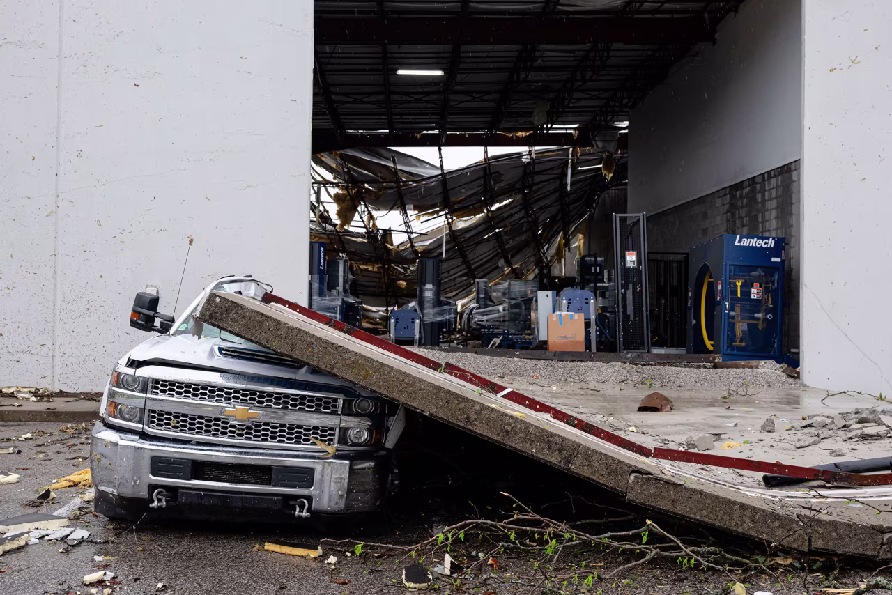 A smashed truck sits under a section of collapsed warehouse wall on Thursday in Jeffersontown, Kentucky.