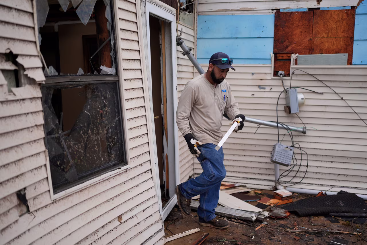 Willy Barns Jr. helps clean up his father's house in Selmer, Tennessee, on Thursday.
