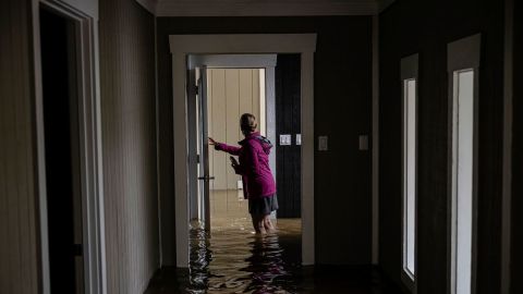 Carole Smith camina por su casa inundada en Frankfort, Kentucky, el sábado.