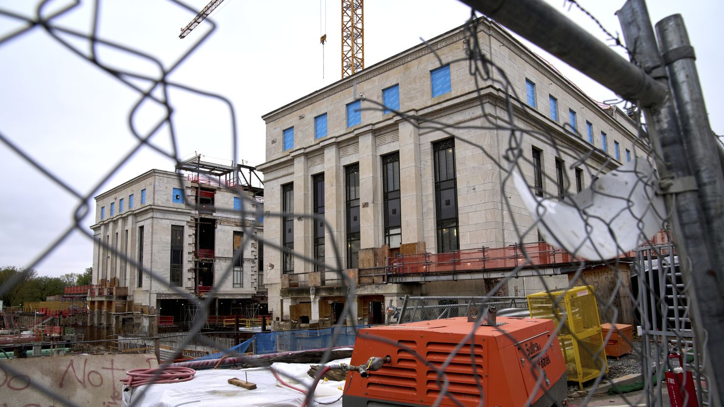 The Marriner S. Eccles Federal Reserve Board Building, which is under construction, is seen, Monday, April 7, 2025, through a hole in construction fencing in Washington.