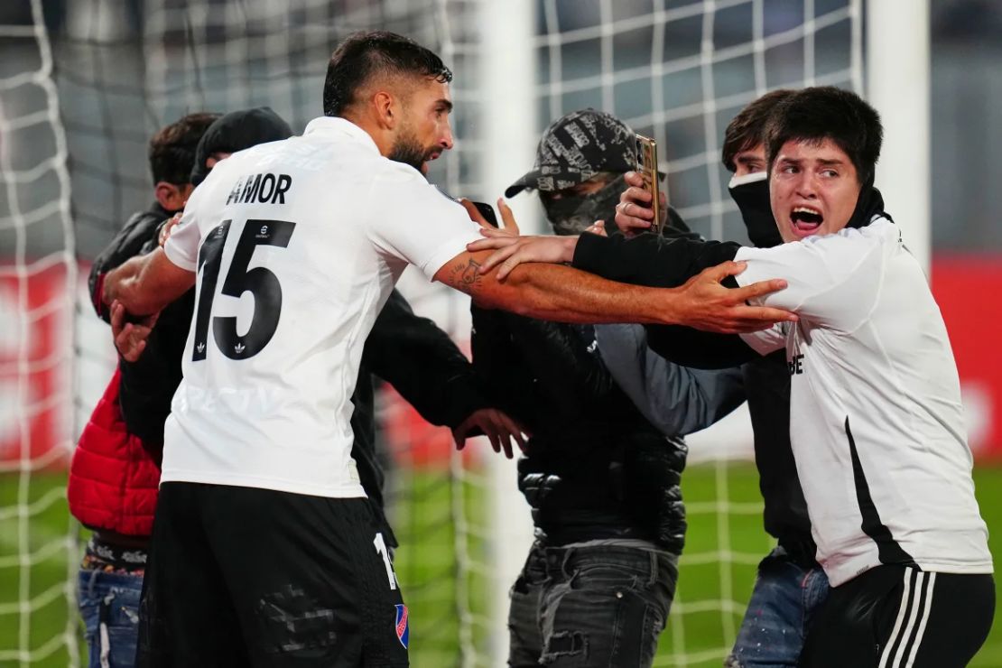 Emiliano Amor, del Colo Colo chileno, con los hinchas que invadieron el campo.