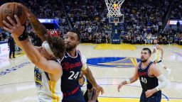 Golden State Warriors guard Brandin Podziemski (2) and Los Angeles Clippers guard Norman Powell (24) compete for a rebound during overtime of an NBA basketball game Sunday, April 13, 2025, in San Francisco.