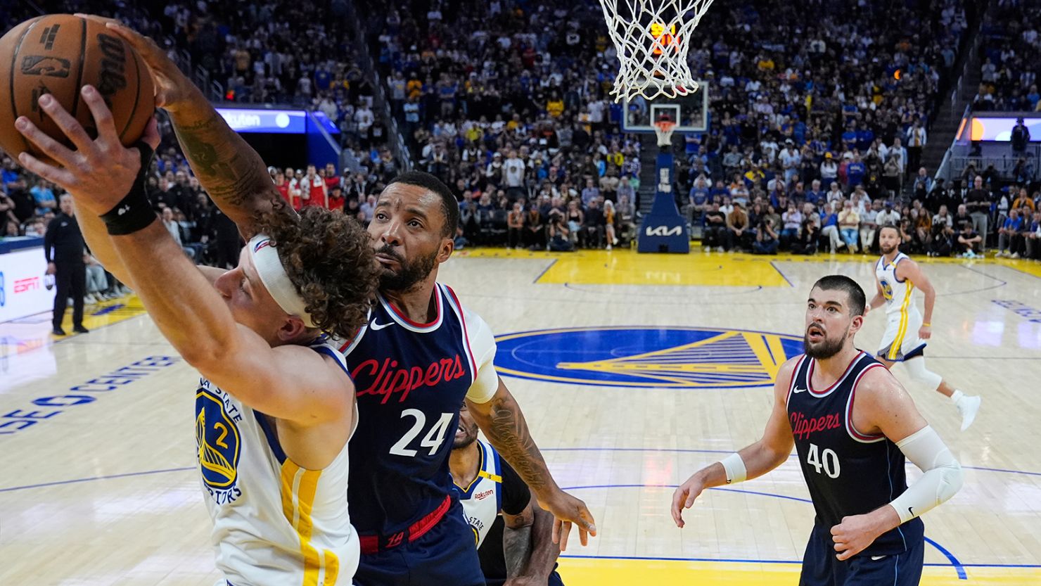 Golden State Warriors guard Brandin Podziemski (2) and Los Angeles Clippers guard Norman Powell (24) compete for a rebound during overtime on Sunday.