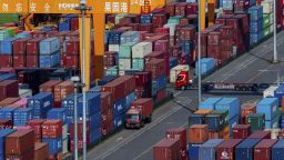 Camiones se mueven entre contenedores apilados en una terminal portuaria en el río Yangtze, en la municipalidad de Chongqing, suroeste de China, el 20 de abril de 2025.