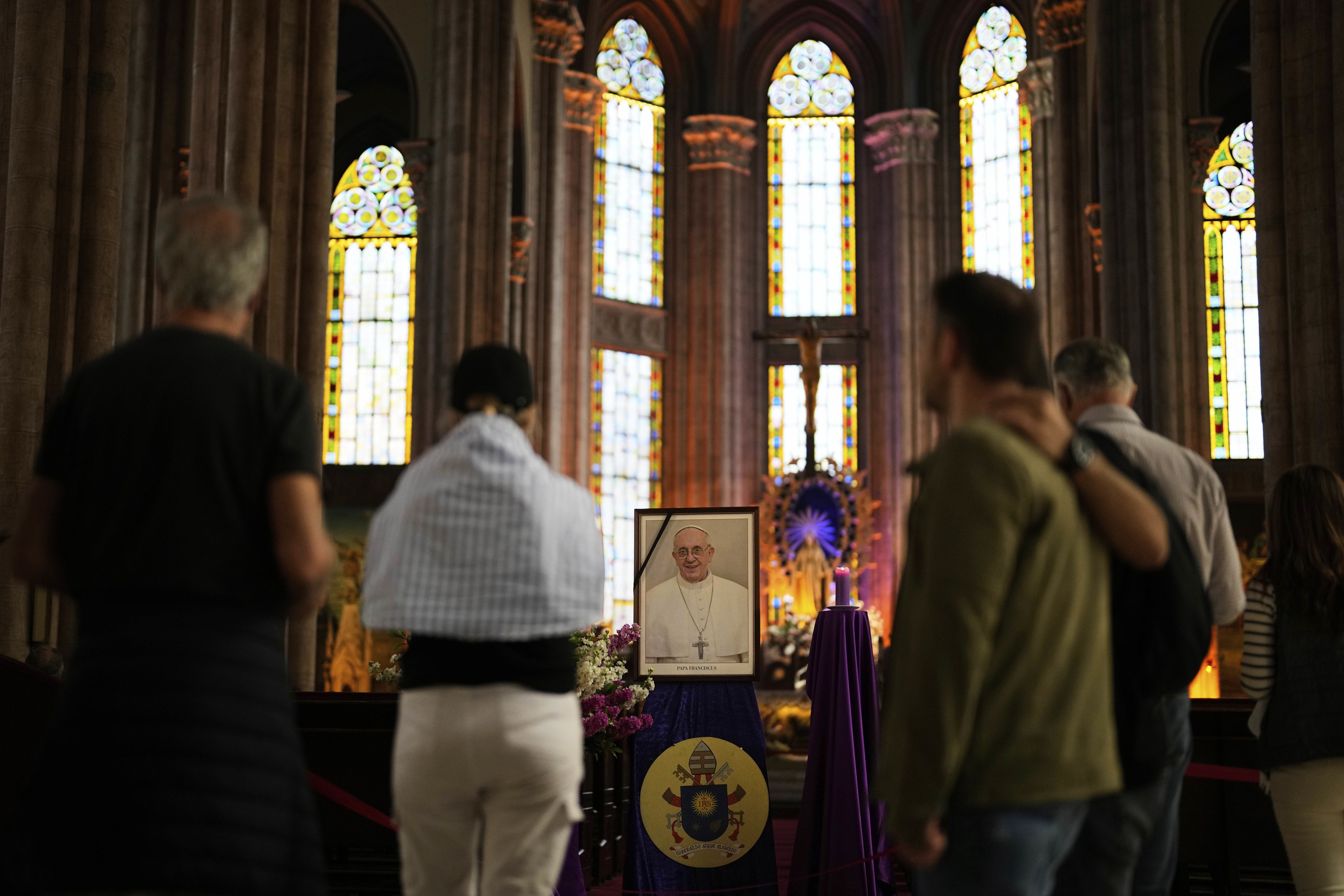 People in Istanbul stand by a photograph of Pope Francis at the Church of St. Anthony of Padua.