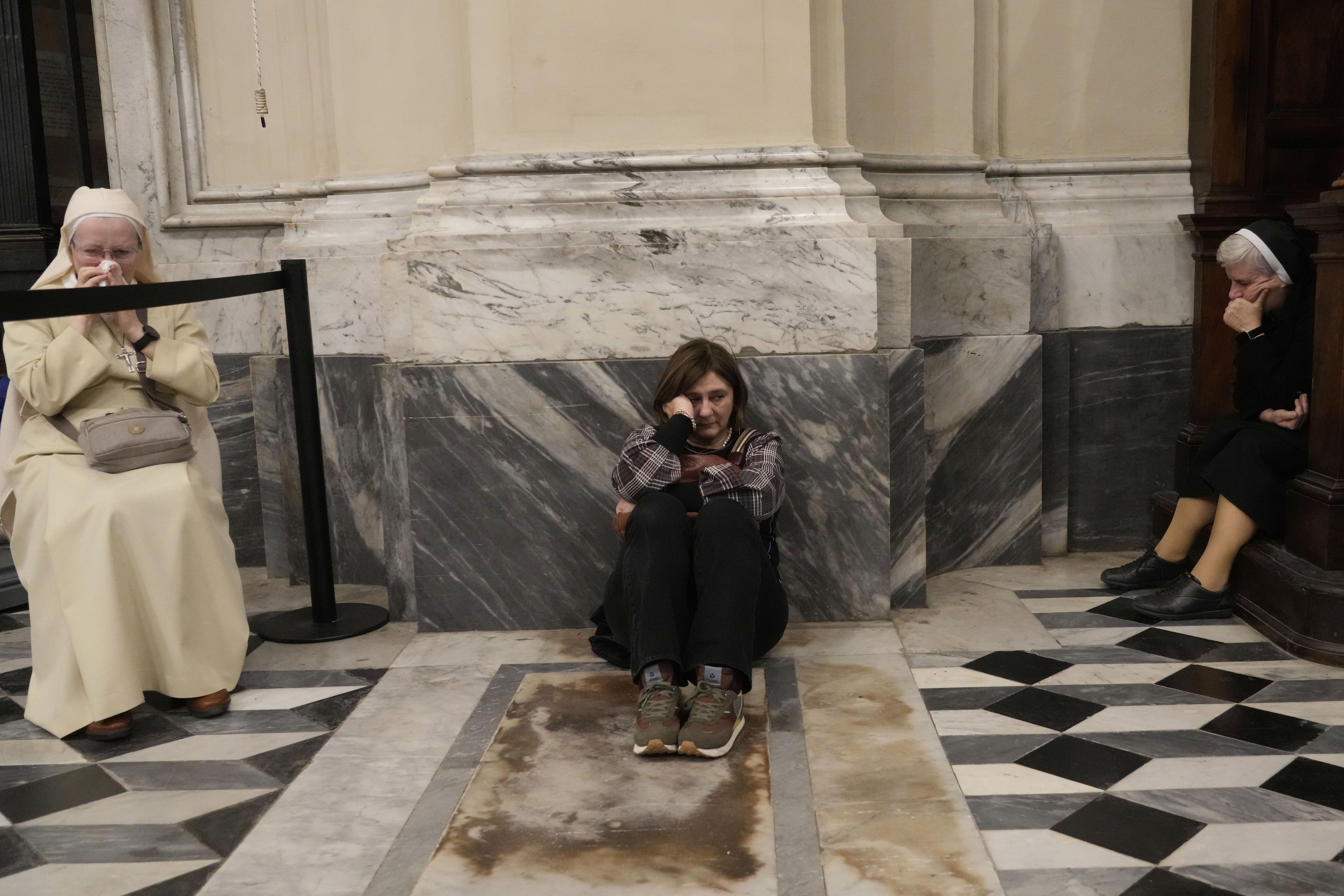 People react as they attend a Mass at the St. John Lateran Basilica in Rome.