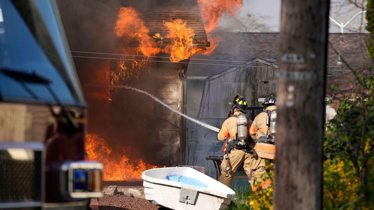 Firefighters battle a house fire Wednesday, April 23, 2025, in Lacey Township, N.J. (AP Photo/Matt Slocum)