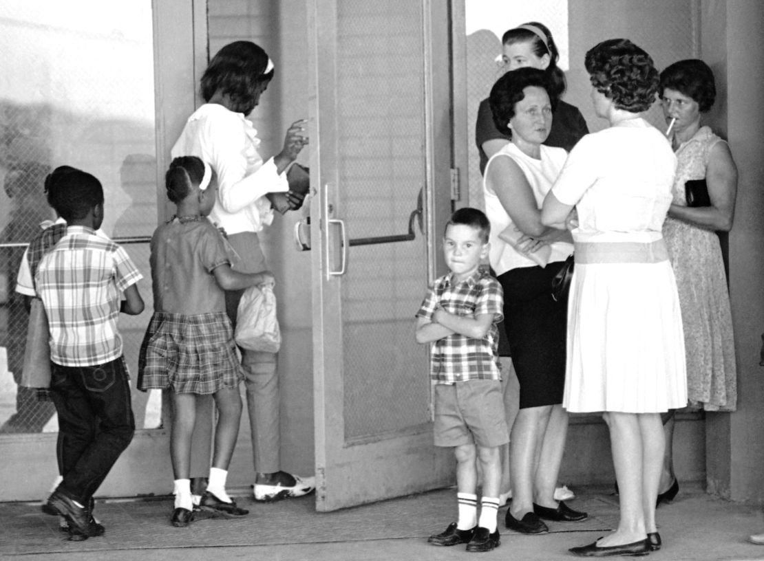 A group of students, left, enter the Boothville-Venice School in Plaquemines Parish, Louisiana, on September 12, 1966 as a group of mothers wait at the entrance of the school.