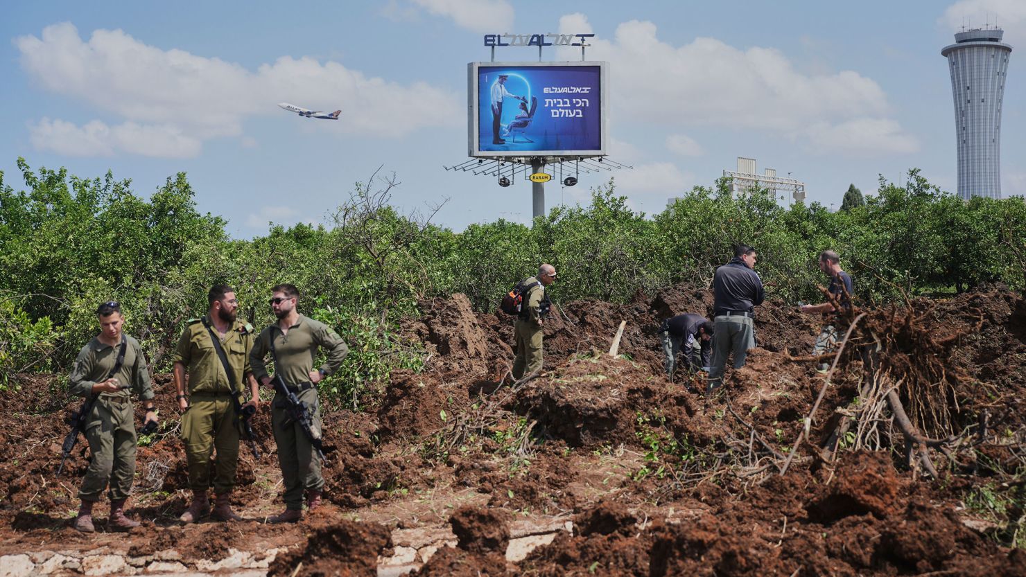 Israeli security forces inspect the site where a projectile fired by Yemen's Houthi rebels landed, near Ben Gurion Airport on Sunday.