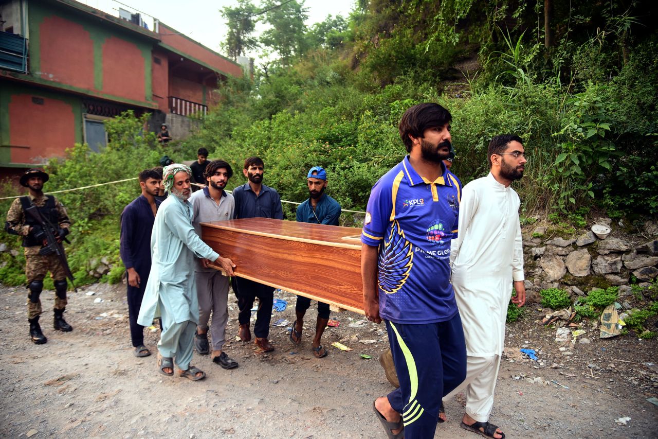Volunteers carry a body after recovering it from the rubble of a mosque near Muzaffarabad, Pakistan-administered Kashmir.