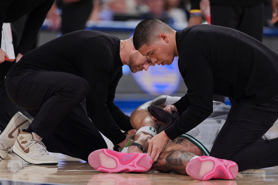 Trainers check on Boston Celtics' Jayson Tatum after he was injured late in the fourth quarter.