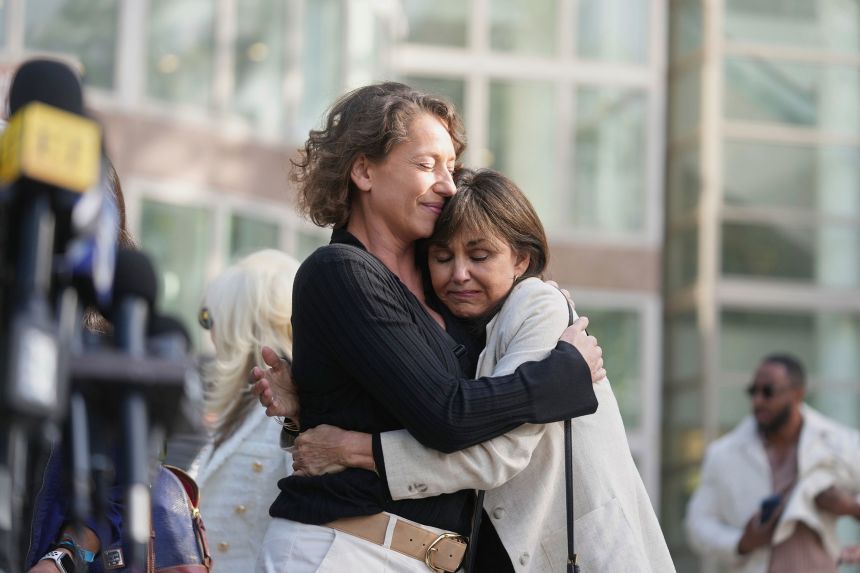 Anamaria Baralt, left, cousin of Erik and Lyle Menendez, left, gets a hug as she leaves the Los Angeles courthouse after the brothers' resentencing hearing on Tuesday.