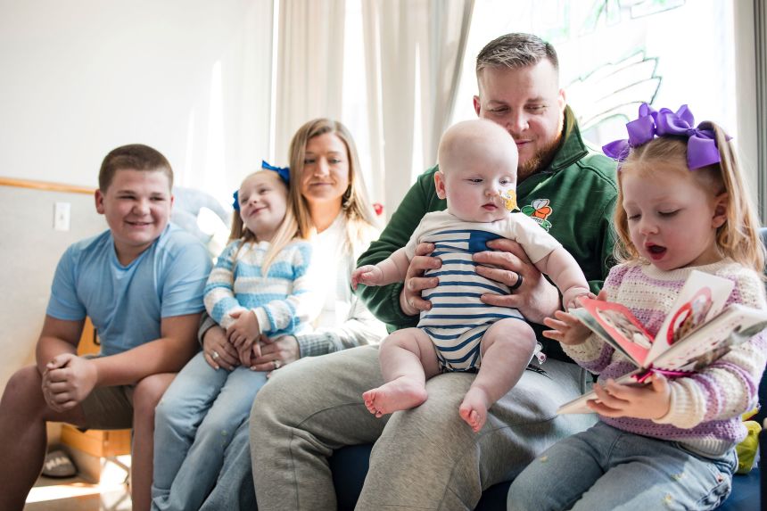 KJ Muldoon sits with his parents, Kyle and Nicole Muldoon, and his siblings in April.