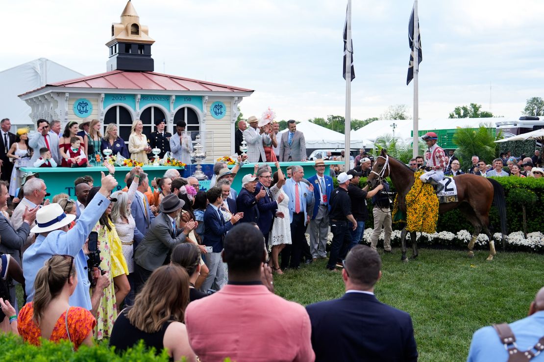 Umberto Rispoli, atop Journalism, celebrates with supporters in the winner's circle.