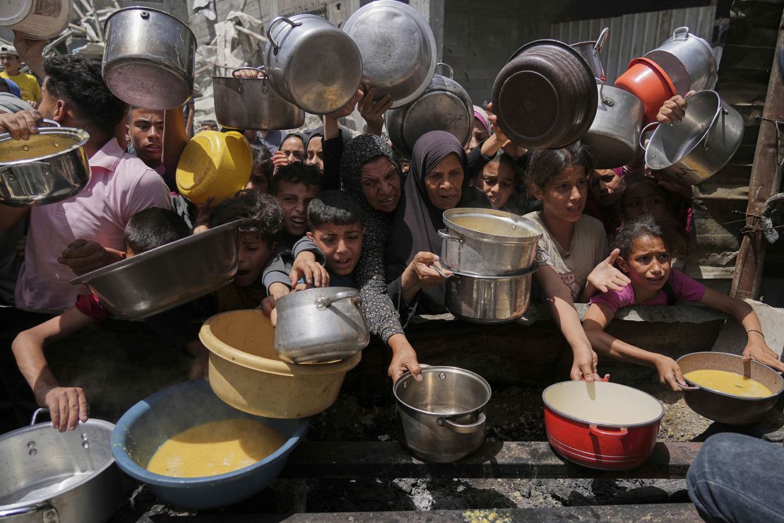 Palestinians struggle to get donated food at a community kitchen in Jabalia, northern Gaza Strip on Monday.
