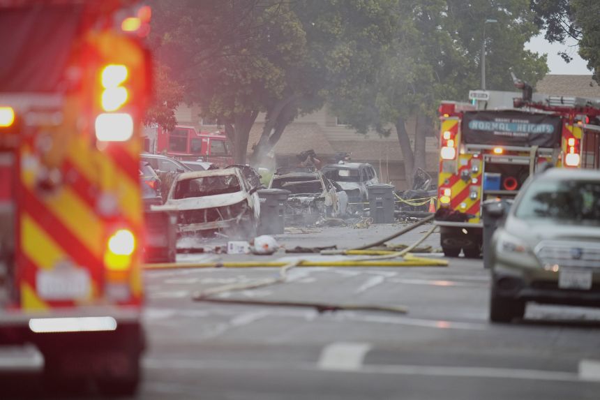 The authorities work in the scene in which a small aircraft fell into a neighborhood in San Diego on Thursday.