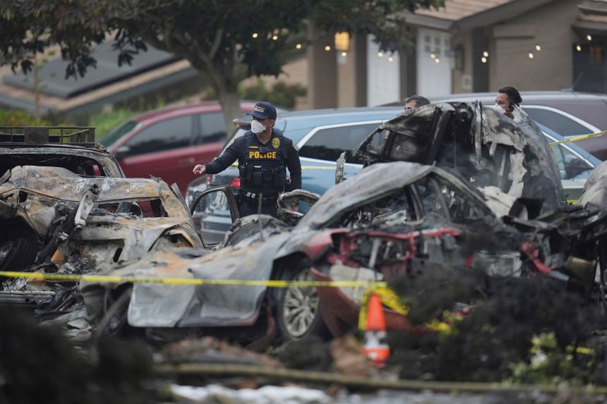 Authorities work the scene where a small plane crashed into a San Diego neighborhood early Thursday.