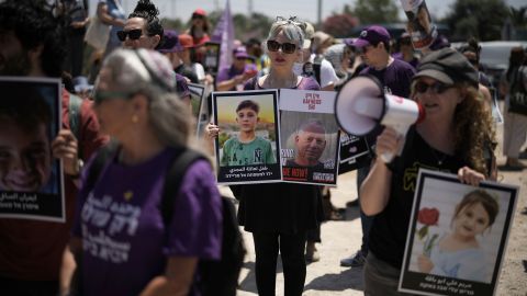 People hold pictures of hostages held by Hamas and children killed by Israeli bombardment in the Gaza Strip at a protest near the Israeli-Gaza border in Sderot, southern Israel, Friday, May 23, 2025.