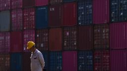 A worker walks by containers at Yangluo Port on the Yangtze River in Wuhan, central China's Hubei Province, on May 23, 2025.
