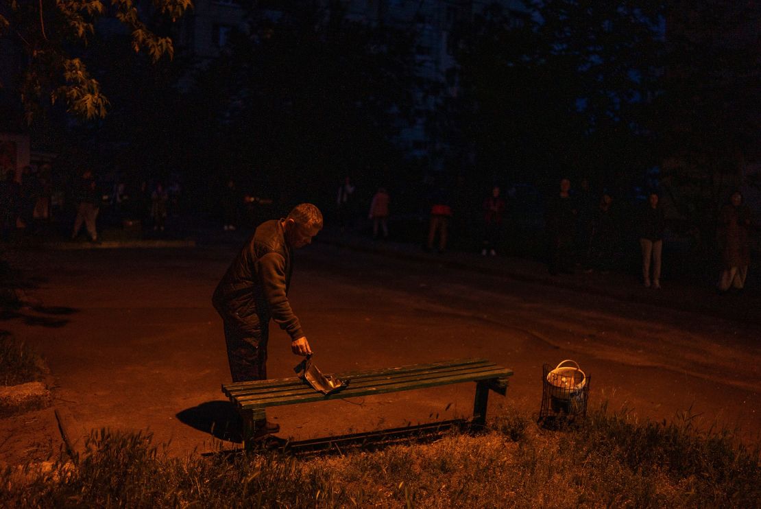 A resident looks at a fragment of a Russian drone, at a residential building that was damaged in the attack.
