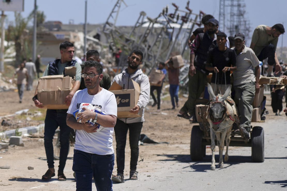 Palestinians carry boxes and bags containing food and humanitarian aid packages delivered by the Gaza Humanitarian Foundation, a US-backed organization approved by Israel, in Khan Younis, southern Gaza Strip, on Thursday.