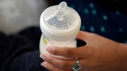 A woman holds a bottle of baby formula as she feeds her infant son in San Antonio on May 13, 2022.