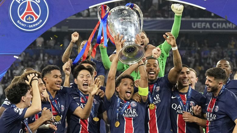PSG's Marquinhos holds up the trophy as he celebrates with his teammates after winning the Champions League final soccer match between Paris Saint-Germain and Inter Milan at the Allianz Arena in Munich, Germany, Saturday, May 31, 2025. (AP Photo/Martin Meissner)