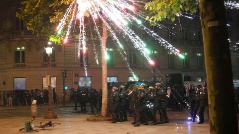 Fireworks explode over riot police officers on the Champs-Elysees in Paris.