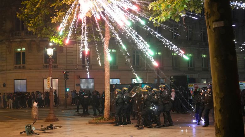 Fireworks explode over riot police officers on the Champs-Elysees in Paris.