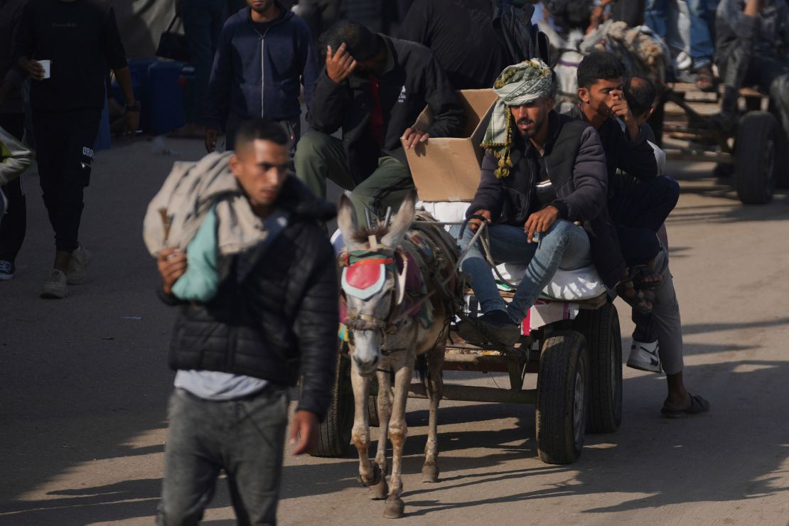 Palestinians wear boxes and bags containing food and humanitarian aid to Khan Younis on Sunday.
