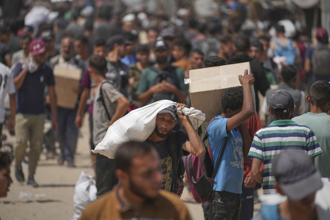 Palestinians carry boxes and bags containing food and humanitarian aid packages provided by the Gaza Humanitarian Foundation earlier this month.