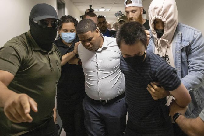 A Dominican man, center, and an activist, right, are detained by plain-clothed officers with Immigration and Customs Enforcement at the immigration court inside the Jacob K. Javitz Federal Building in New York on Friday.