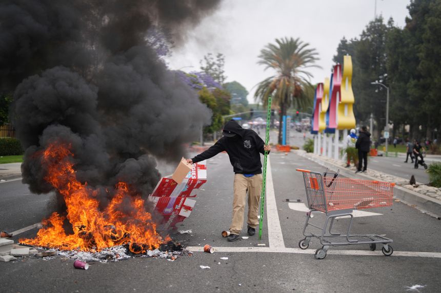 A protester places debris in a fire.