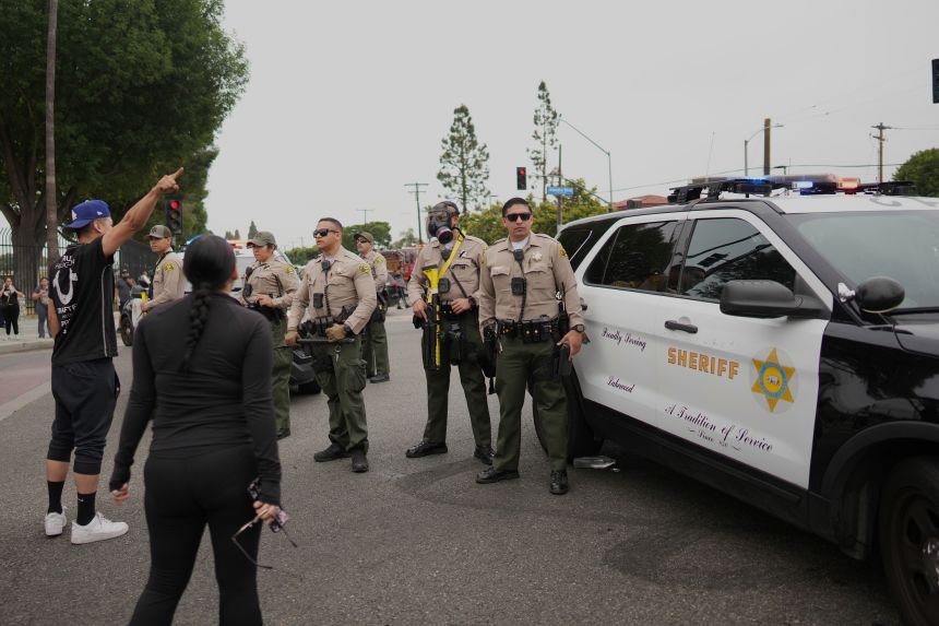 Protesters confront Border Patrol personnel in the Paramount section of Los Angeles on Saturday.