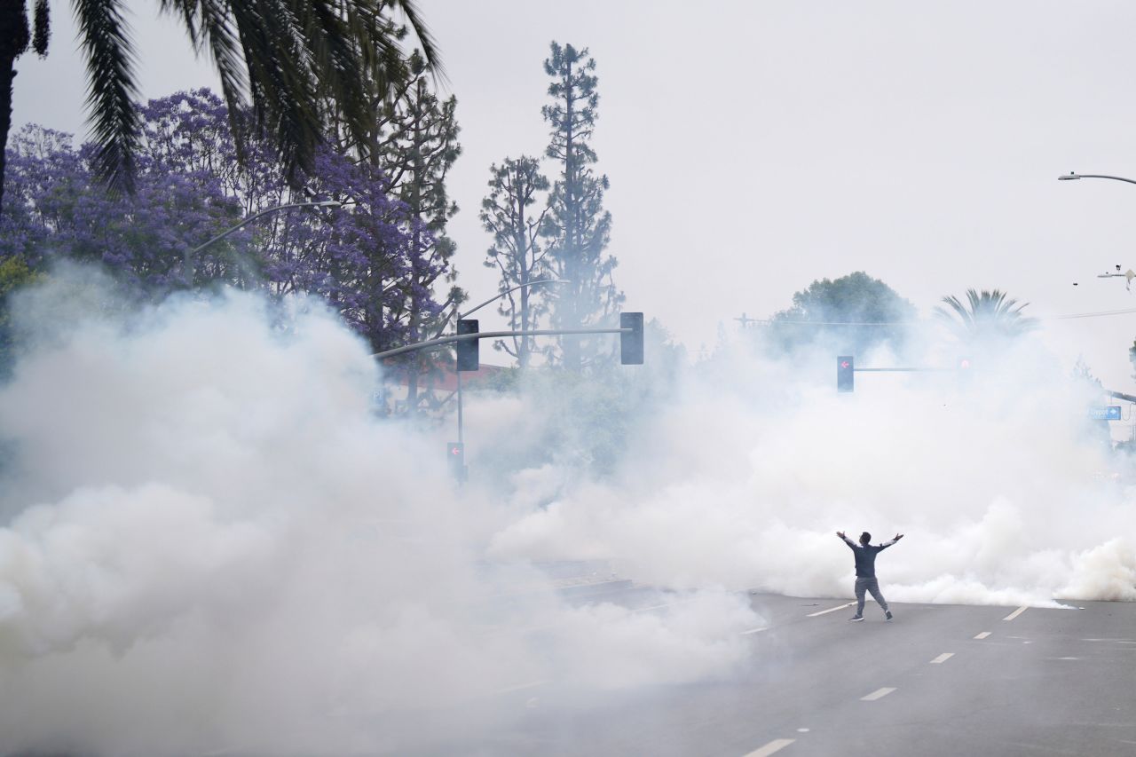 Tear gas fills the street as a protester confronts Border Patrol personnel during a demonstration in Paramount, California, on Saturday.