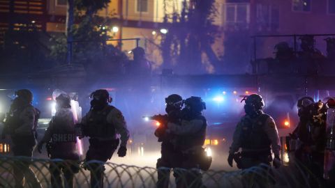 Law enforcement stand during a protest in Compton, Calif., Saturday, June 7, 2025, after federal immigration authorities conducted operations. (AP Photo/Ethan Swope)