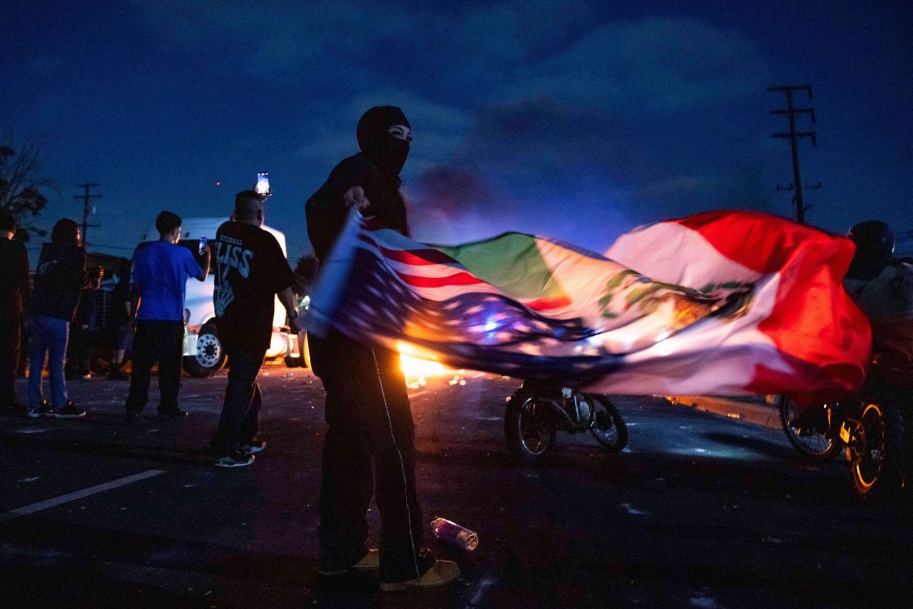 A demonstrator waves a US and Mexican flag during a protest in Compton, California, on Saturday.