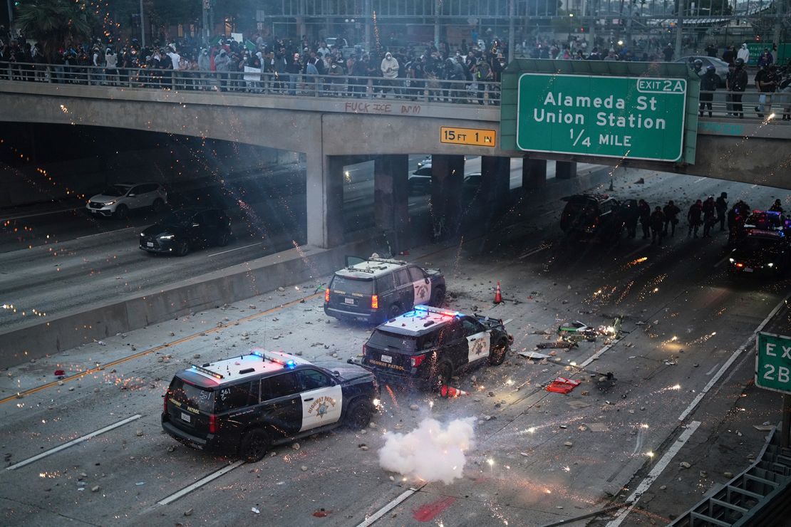 A flash bomb explodes on the 101 Freeway near the metropolitan detention center of downtown Los Angeles, on Sunday, following last night's immigration raid protest.