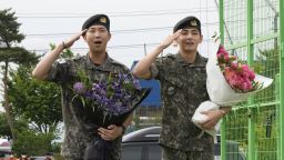 K-pop band BTS members RM, left, and V salute after being discharged from a mandatory military service in Chuncheon, South Korea, Tuesday, June 10, 2025.