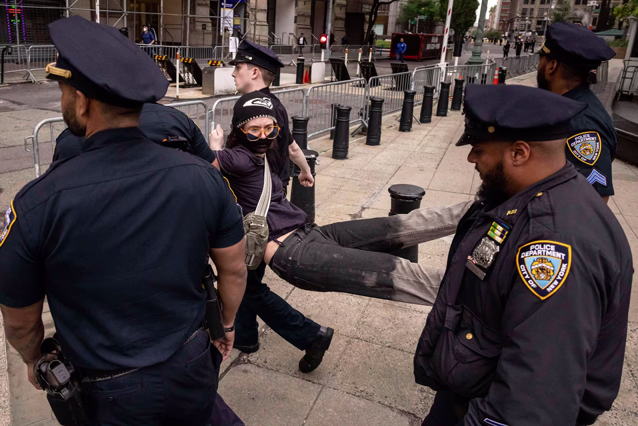 NYPD officers carry a detained demonstrator during a protest against deportation by Immigration and Customs Enforcement outside Jacob K. Javits Federal Building in New York, on Monday.