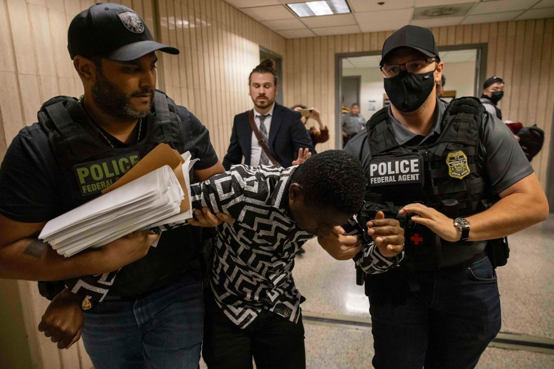 Federal agents detain a person outside an immigration courtroom in New York City in June.