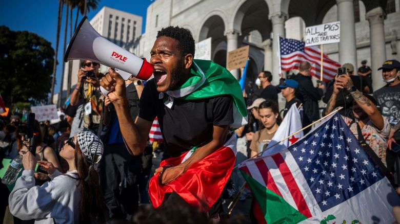 A man shouts into a megaphone outside City Hall during a protest over federal immigration enforcement raids on Wednesday, June 11, in Los Angeles.