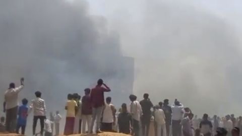 People watch smoke rising after an airplane crashed in Ahmedabad, Gujarat state, India, Thursday, June 12, 2025. (Mohan Nakum via AP)